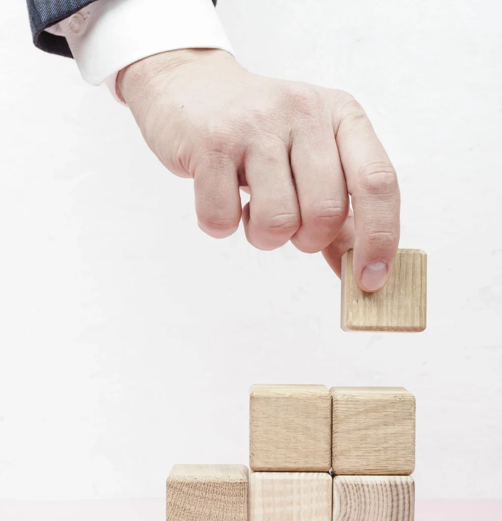 hand-creating-stairs-from-wooden-cubes-min-986x1536